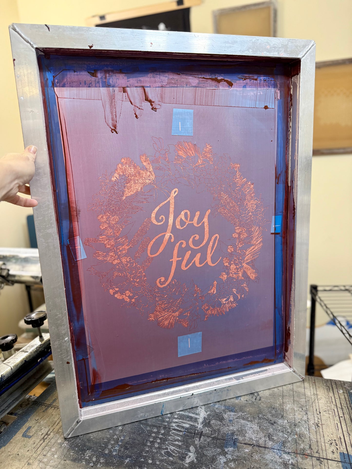 Hand-printed joyful holiday tea towel with festive botanical design