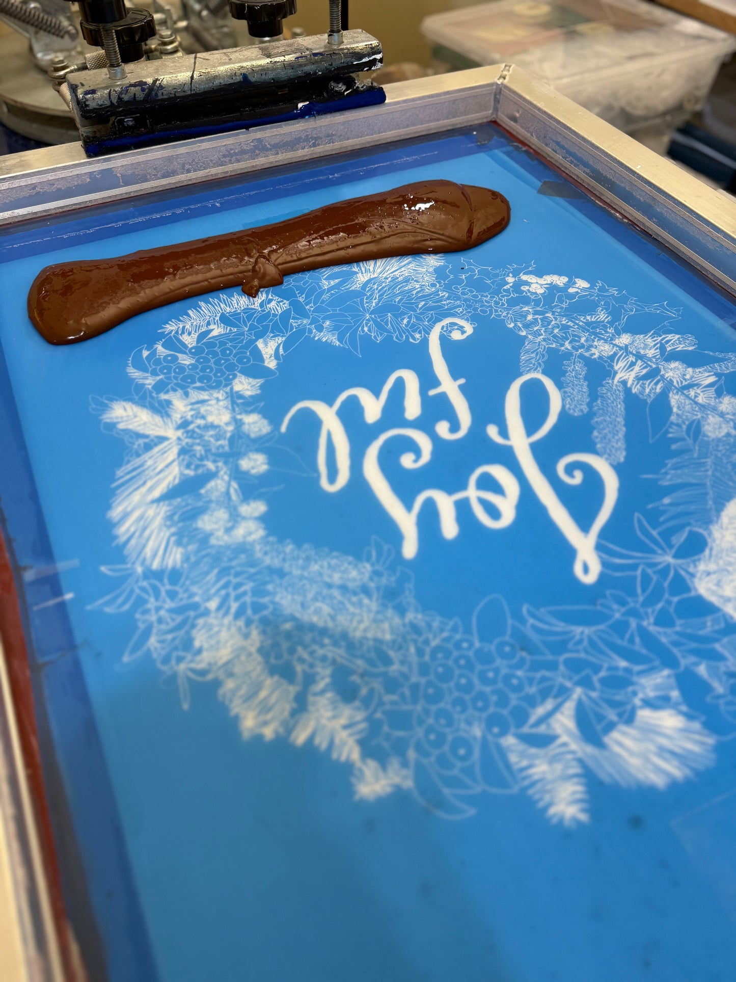 Hand-printed joyful holiday tea towel with festive botanical design