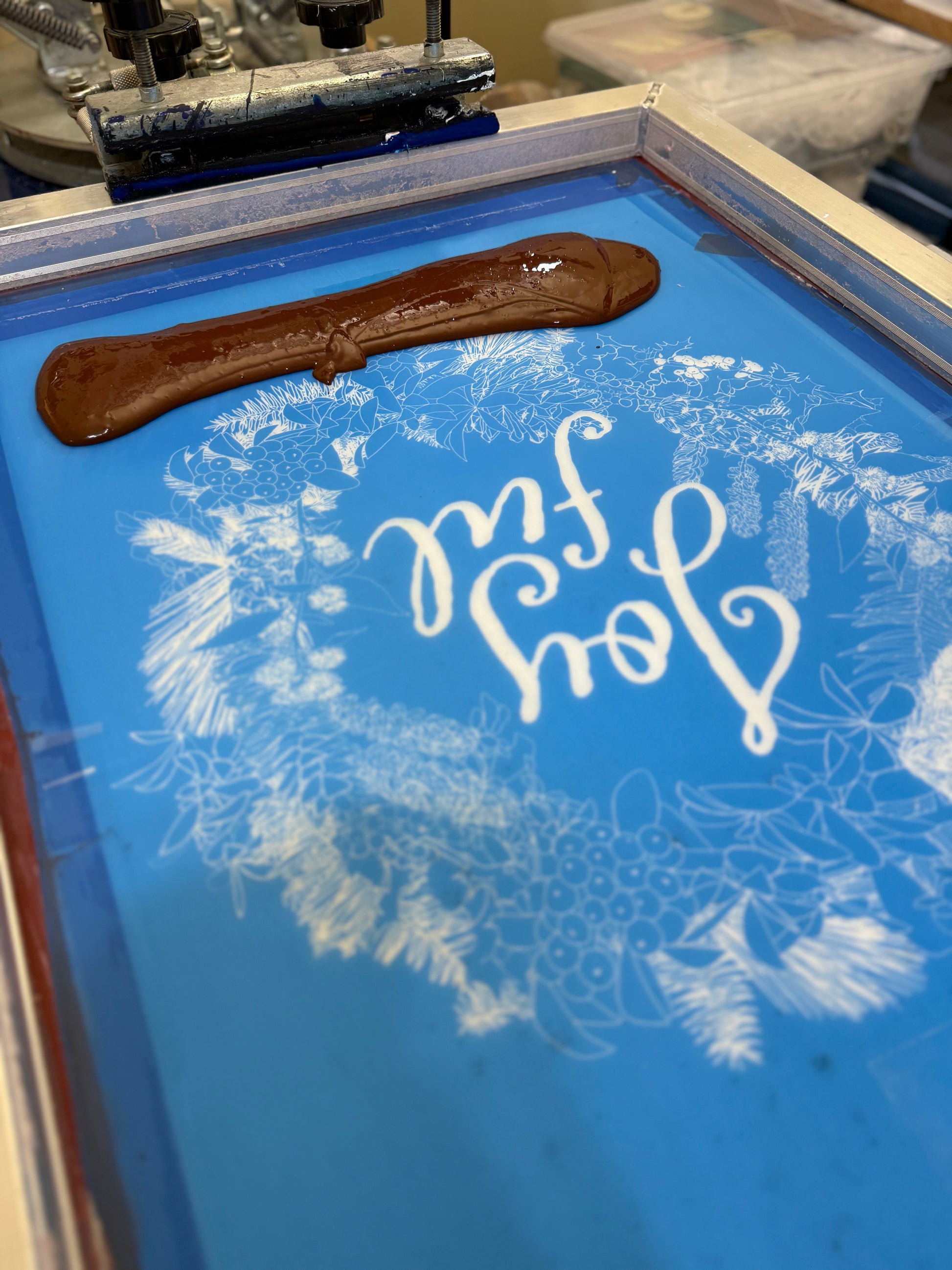 Hand-printed joyful holiday tea towel with festive botanical design